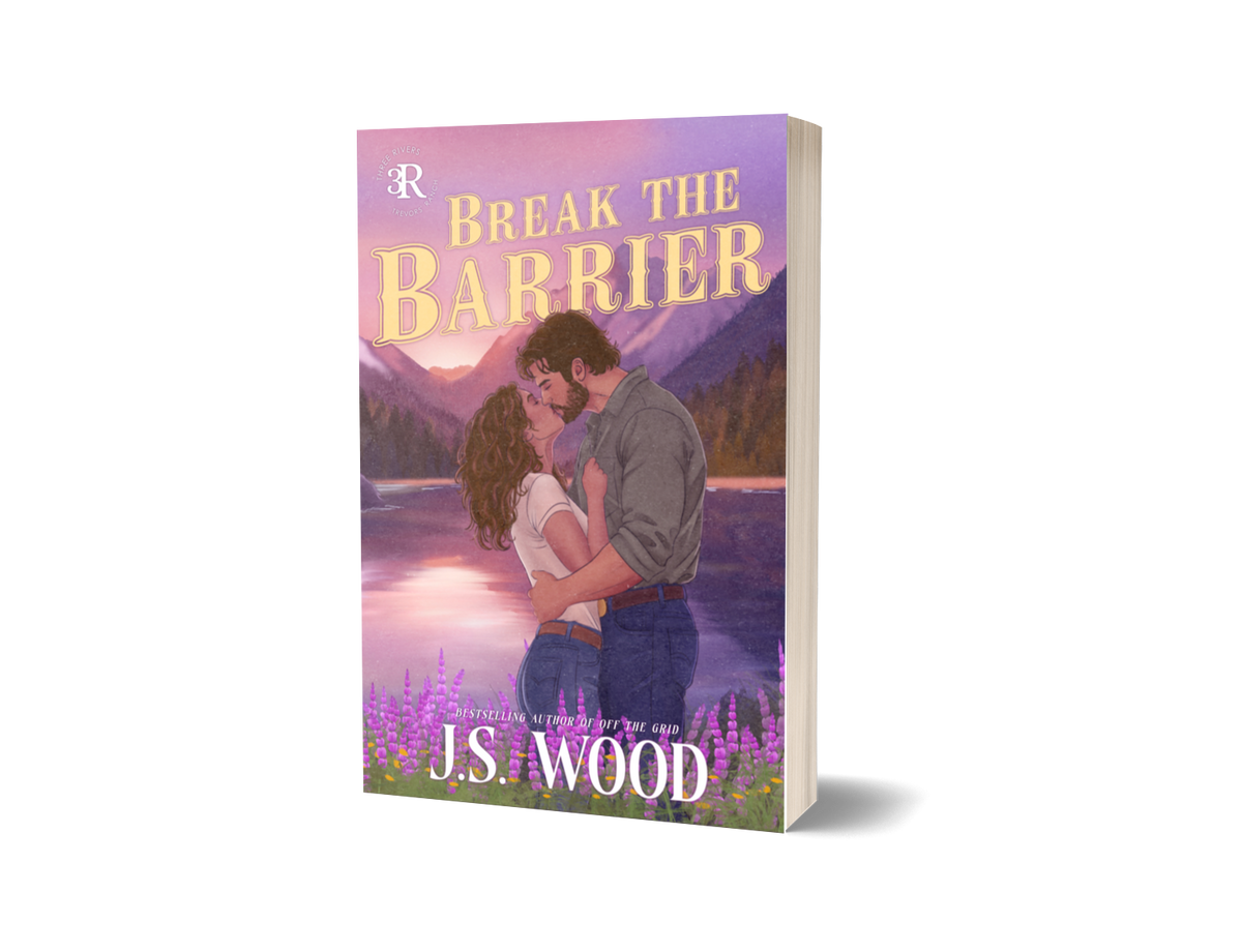 Break the Barrier by J.S. Wood paperback with a couple kissing and a hand drawn mountain background with purple flowers. Yellow title "Break The Barrier". Part of the Three Rivers Trevors Ranch series by J.S. wood